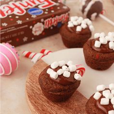 chocolate cupcakes with marshmallows and candy canes on a plate