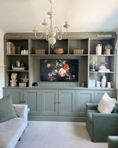 a living room filled with furniture and a chandelier hanging from the ceiling above it