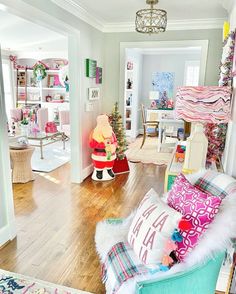 a living room filled with lots of furniture and christmas decorations on top of wooden floors