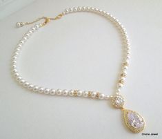 "This glamorous necklace has a cubic zirconia teardrop pendant and Swarovski pearls in white. Necklace is strung with 6 mm Swarovski pearls and accented with rhinestone rondelles for a fabulous old Hollywood glamour look! It is finished off with a lobster claw closure and a 2\" extender chain for additional length. Please choose desired pearl color, length and finish at checkout. Keep in mind that this necklace has an additional 2\" extender. If you choose a 16\" long it will extend to 18\" long White Cubic Zirconia Bridal Necklace With Pearl Drop, White Pearl Drop Bridal Necklace With Cubic Zirconia, White Cubic Zirconia Pearl Drop Necklace, Wedding Pearl Necklace With Teardrop Pendant, White Pear-shaped Necklace For Wedding, White Pear-shaped Wedding Necklace, White Pearl Pendant Drop Necklace For Wedding, White Teardrop Pendant Bridal Necklace, Pear-shaped Pearl Necklaces For Wedding