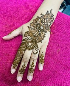 a woman's hand with henna tattoos on it