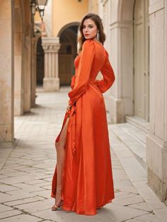 a woman in an orange dress is posing for the camera