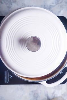 an overhead view of a pot on a stove with two pans next to it