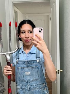 a woman is taking a selfie in the mirror with some scissors on her head