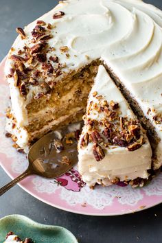 a cake with white frosting and chopped pecans on top is cut from the plate