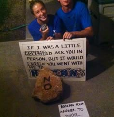 a man and woman sitting next to each other in front of a sign that says if i was a little