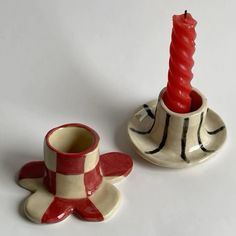 two small ceramic candlesticks sitting next to each other on a white table top