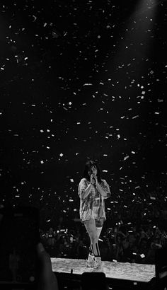 a man standing on top of a stage surrounded by confetti thrown in the air