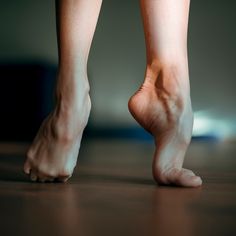 a person with bare feet standing on a wooden floor