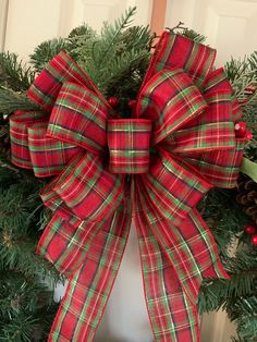 a red and green plaid christmas wreath with pine cones