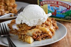 a white plate topped with food next to a container of ice cream on top of a wooden table