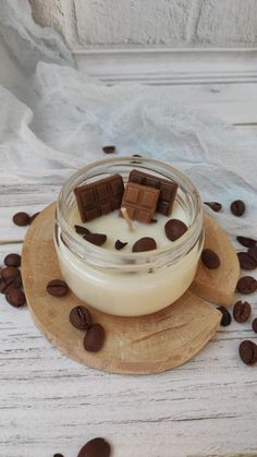 a glass jar filled with milk and chocolate chips sitting on top of a wooden coaster