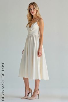 a woman in a white dress posing for the camera with her hands on her hips