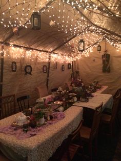 a dining room with lights strung from the ceiling and tables covered in tablecloths