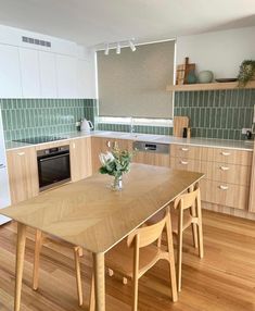 a wooden table sitting in the middle of a kitchen next to a stove top oven