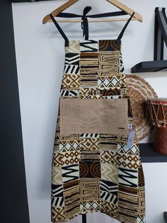 "Make your kitchen beautiful with this handmade African Print Apron with Pocket. Crafted from 100% cotton, this apron features a colorful fabric, deep pockets, and fits US sizes 6-12. Plus, the fabric retains its vibrant color even after washing. Make cooking fun with this signature piece that will add joy, color, and life to your kitchen. Handmade with durable 100% Cotton Fabric. Retains colour after multiple washes Handmade African Print Apron | Traditional African \"Bogolan\" Print Apron Mash Modern African Decor, Traditional Aprons, Fashion Apron, Handmade Aprons, Fabric Photography, Patch Work Blouse, Oven Gloves, Cute Aprons, Printed Aprons