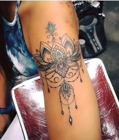 a woman's arm with a tattoo on it that has a flower and feathers