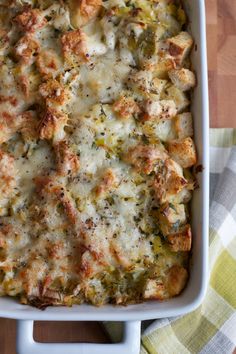 a casserole dish with chicken, broccoli and cheese in it on a wooden table