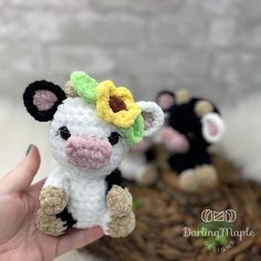 a small stuffed cow with a flower on it's head