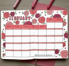 a pink and red planner with flowers on it, next to two pencils that are laying