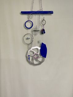 there is a wall hanging with various items attached to it and some chains on the hooks