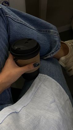 a person holding a coffee cup in their lap