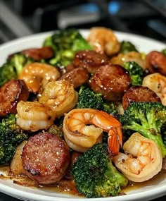 a white plate topped with shrimp, broccoli and sausage