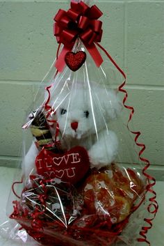 a teddy bear sitting in a basket filled with treats