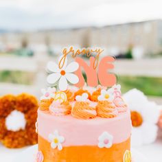 an orange and pink cake sitting on top of a table