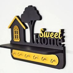 there is a black and yellow sign that says sweet home with a house on it