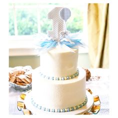 a three tiered cake with blue and white decorations