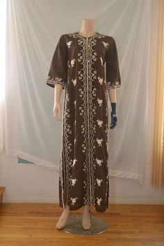 Vintage 60's/70's maxi kaftan dress with floral embroidery, side vents, bell sleeves and buttons all the way down the front. Material seems like a cotton blend. Excellent condition.  W:20" S:21" L:58" Bohemian Fitted Maxi Dress With Chikankari Embroidery, Fitted Long Sleeve Kaftan With Floral Embroidery, Spring Floral Embroidered Long Abaya, Spring Long Abaya With Floral Embroidery, Spring Abaya With Floral Embroidery, Spring Floral Embroidered Abaya, Bohemian Style Long Brown Thobe, Bohemian Style Brown Long Thobe, Brown Bohemian Long Thobe