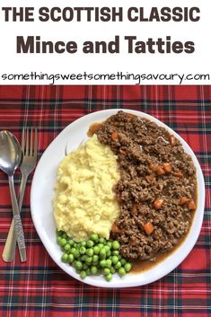 a white plate topped with mashed potatoes, meat and peas next to a fork