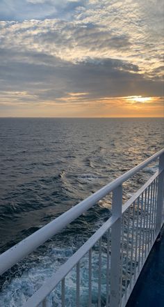 the sun is setting over the ocean as seen from a ferry