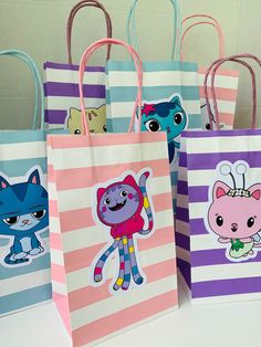 four bags with cartoon characters on them are sitting on a table and one bag is pink, purple, blue, and white