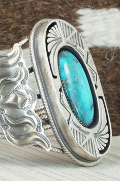 This vintage turquoise and sterling silver bracelet was made by a Navajo silversmith. The inside is signed RB and stamped sterling. Please note this is a pre-owned piece, with patina, in vintage condition.Size: 5 1/2" (will fit up to a 6 1/2" wrist)Gap: 1"Width: 2 3/8"Free shipping on all orders! We ship with USPS and always include tracking. All orders ship within a day of payment.Returns are accepted up to 30 days after you receive your order. Just send us a message. Our shop offers cash back Silver Western Cuff Bracelet With Patina, Vintage Turquoise Concho Cuff Bracelet, Vintage Turquoise Cuff Bracelet With Concho, Western Silver Bracelet With Patina, Vintage Turquoise Bracelets With Inlay, Vintage Turquoise Bracelet With Inlay, Southwestern Stamped Turquoise Ring, Vintage Handmade Turquoise Sterling Silver Bracelet, Handmade Vintage Turquoise Sterling Silver Bracelet