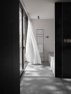 a white curtain hanging from the side of a room