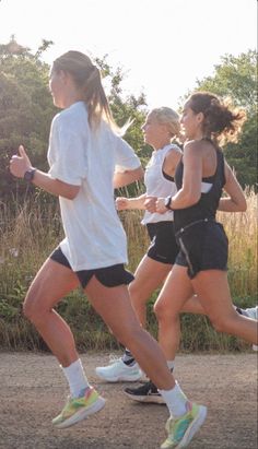 three women running in a race with trees in the background