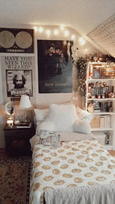 a bedroom with bookshelves and pictures on the wall above the bed is decorated in gold and white