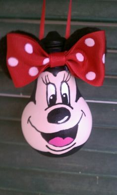 a minnie mouse head with a red bow hanging from it's side on a wall