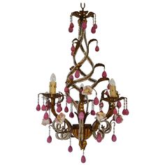 a chandelier with pink beads hanging from it's center and two lights on each side