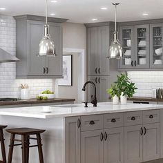 a kitchen with gray cabinets and white counter tops