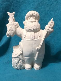 a white ceramic figurine with an owl on it's arm holding two fish