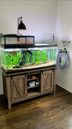 a fish tank is sitting on top of a wooden cabinet in front of a wall