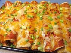 a cheesy casserole with green onions and cheese on the top is ready to be eaten