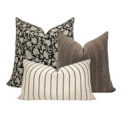 three pillows with black and white stripes on the front, two in grey and one in beige