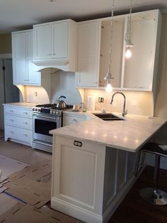 a kitchen with white cabinets and an island in the middle is being remodeled by someone