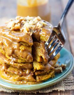 a stack of pancakes covered in caramel glaze with a fork stuck into it