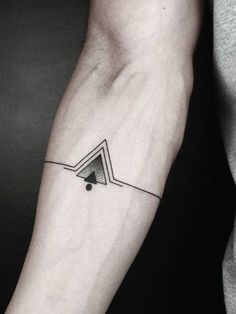 a black and white photo of a person's arm with a triangle tattoo on it