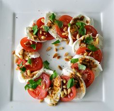 a white plate topped with sliced tomatoes and pita bread